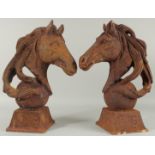 A PAIR OF CAST IRON HORSE'S HEADS on square bases. 18ins high.