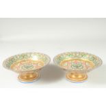 A SUPERB PAIR OF RUSSIAN PORCELAIN CIRCULAR COMPORTS. 8.75ins diameter, 3.5ins high. The centre with