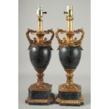 A PAIR OF TALL FAUX MARBLE AND GILT URN SHAPED LAMPS on pedestal bases. 28ins high.