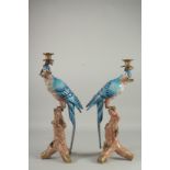 A LARGE PAIR OF BLUE PARROT CANDLESTICKS on rustic bases. 20ins high.
