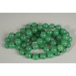 A STRING OF JADE BEADS 28ins long.