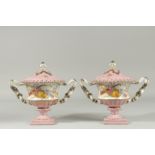 A PAIR OF PINK SEVRES DESIGN CIRCULAR TWO HANDLED CACHE POTS AND COVERS. 8ins high.