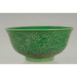 A CHINESE GREEN PORCELAIN CIRCULAR BOWL the sides with dragons. Mark in blue. 6ins diameter.