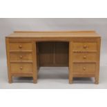 ROBERT "MOUSEMAN" THOMPSON. AN OAK KNEEHOLE DRESSING TABLE, with adzed rectangular top , panelled