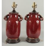 A PAIR OF CHINESE SANG DE BOEUF PORCELAIN LAMPS. 18ins high.