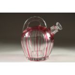 A SLICE CUT RUBY TINTED GLASS EWER with stopper. 7ins high.