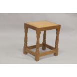 ROBERT "MOUSEMAN" THOMPSON. AN OAK STOOL with close nailed tan leather seat, on four stretchered