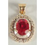 AN 18CT YELLOW GOLD RUBY AND DIAMOND OVAL PENDANT.