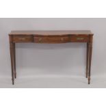 A REGENCY DESIGN MAHOGANY LONG SIDE TABLE with bow front, cross banded top, single frieze top on