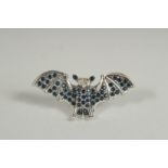 A SILVER SAPPHIRE AND DIAMOND BAT BROOCH.