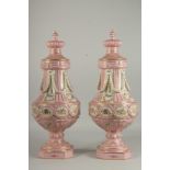 A GOOD PAIR OF SEVRES DESIGN PINK PORCELAIN VASES AND COVERS with garlands and panels of flowers.