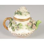 A 19TH CENTRUY ROCKINGHAM MINIATURE TEA POT AND COVER encrusted with flowers, printed griffin mark.