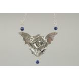 A SILVER ART DECO STYLE FIGURES AND WINGS PENDANT AND CHAIN.