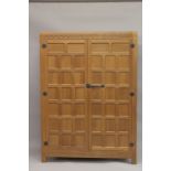 ROBERT "MOUSEMAN" THOMPSON. AN OAK TWO DOOR WARDROBE with a pair of panelled doors, panelled ends,