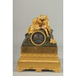 A GOOD EMPIRE ORMOLU AND BRONZE CLOCK the case with two gilded figures. 13ins high.