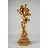 A CARVED GILDED CHERUB LAMP. 23ins high.
