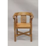 ROBERT "MOUSEMAN" THOMPSON. AN OAK SMOKERS BOW ARMCHAIR, with a curving broad arm, lattice work