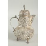 A GOOD CONTINENTAL SILVER COFFEE POT with all over repousse decoration supported on three claw feet.