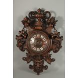 A LARGE CARVED WOOD CLOCK with urns and acanthus scrolls. 28ins high.