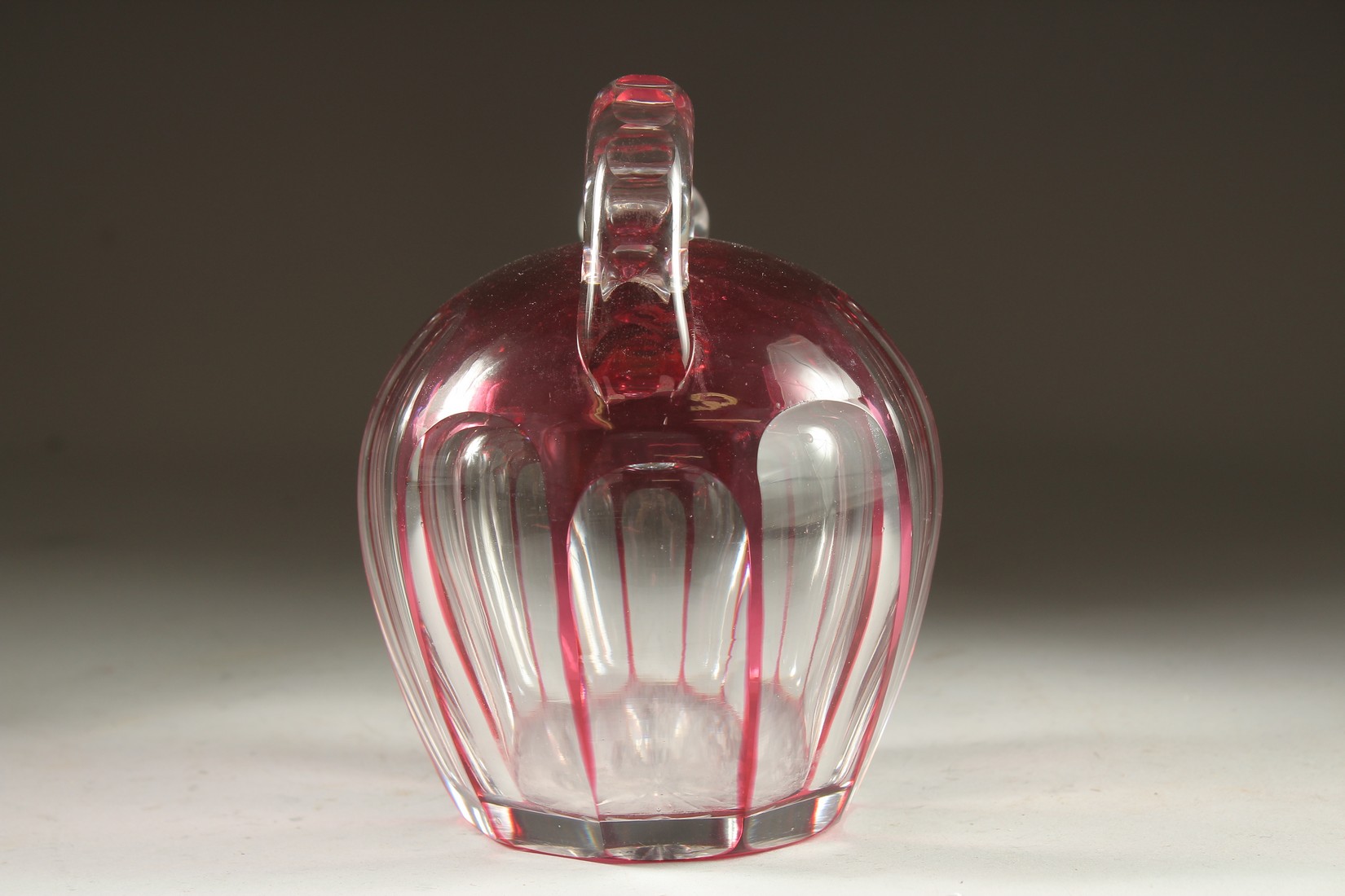 A SLICE CUT RUBY TINTED GLASS EWER with stopper. 7ins high. - Image 4 of 5