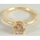 AN 18CT YELLOW GOLD FANCY SINGLE STONE RING and a band of diamonds around the shank..