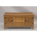 ROBERT "MOUSEMAN" THOMPSON. AN OAK LONG SIDEBOARD with adzed rectangular top, panelled ends, three