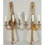 A PAIR OF GILT METAL THREE LIGHT WALL SCONCES. 25ins long.