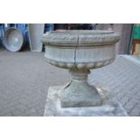 A composite circular pedestal garden planter (cracked).