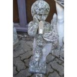 A composite garden ornament modelled as a cherub holding a bowl of fruit.