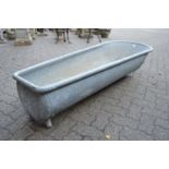 A large galvanised bath tub/planter.