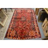 Persian design carpet red ground with stylised floral decoration (one end trimmed) 240cm x 145cm.