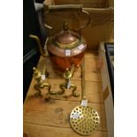 A copper and brass kettle, pair of brass fire dogs and a brass skimmer.
