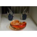 Two glass fish and an orange glass bowl.