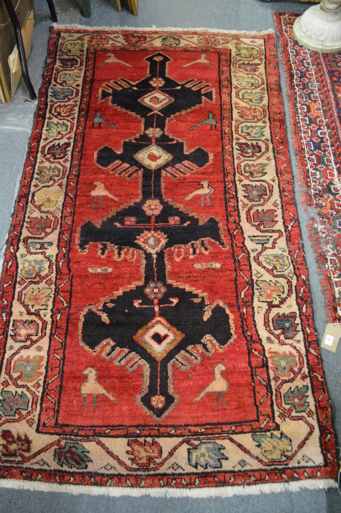 A Persian design carpet, red ground with stylised bird decoration 185cm x 102cm.