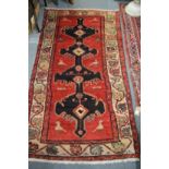 A Persian design carpet, red ground with stylised bird decoration 185cm x 102cm.