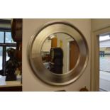 A modern circular wall mirror with silver coloured frame.