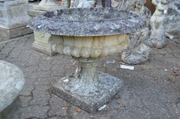 A large classical style urn shaped circular pedestal garden planter.