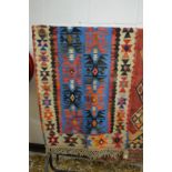 A small flat weave kilim rug, central blue ground with stylised decoration 155cm x 80cm.