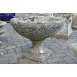 A large circular composite garden pedestal planter.