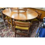 A teak drop leaf gateleg dining table with four dining chairs.