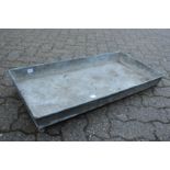 A rectangular galvanised trough or planter.