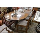 A mahogany twin pedestal dining table with one leaf.