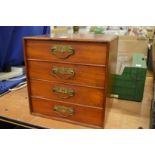 A mahogany table top four drawer chest.