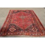 A Persian design carpet, red ground with stylised decoration 290cm x 220cm.