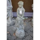 A composite garden ornament modelled as a seated female figure.