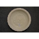 A Chinese white glazed moulded pottery circular dish.