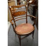 An Edwardian inlaid mahogany open armchair.