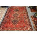A Persian design carpet, red ground with stylised animal and bird decoration 215cm x 180cm.