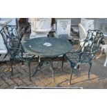 A green painted aluminium circular patio table with a pair of armchairs.