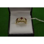 An 18ct gold ring with three clusters comprising rubies and diamonds size N.